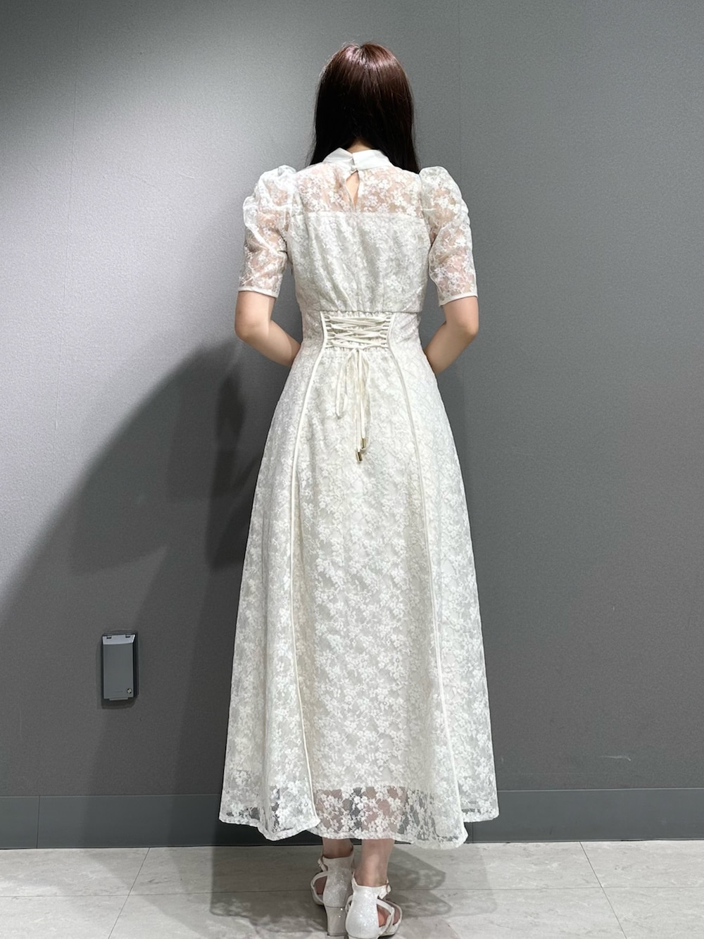 ホワイト系のドレス、ホワイト系のサンダルを着用したレディースの夏コーディネートの7枚目の写真