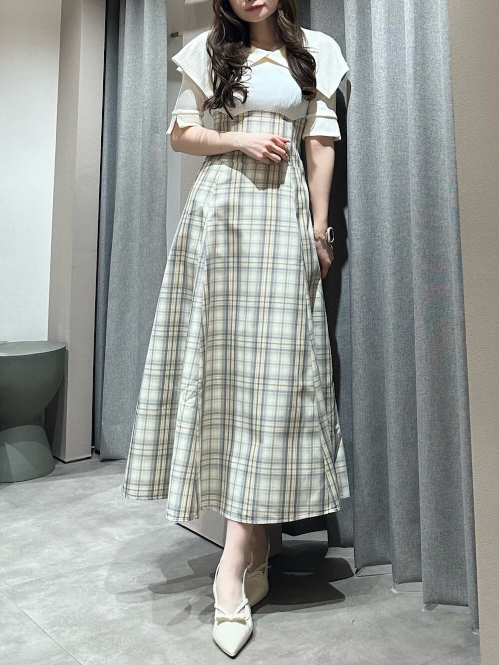 ホワイト系のパンプス、ホワイト系のワンピースを着用したレディースの春コーディネートの3枚目の写真