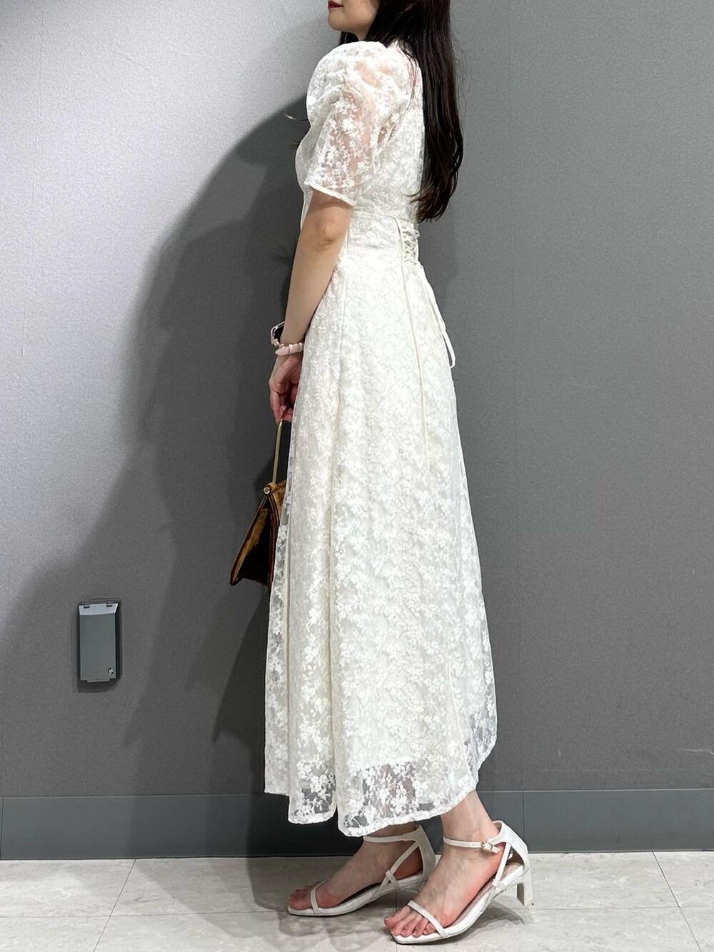 ホワイト系のドレス、ホワイト系のサンダルを着用したレディースの夏コーディネートの5枚目の写真