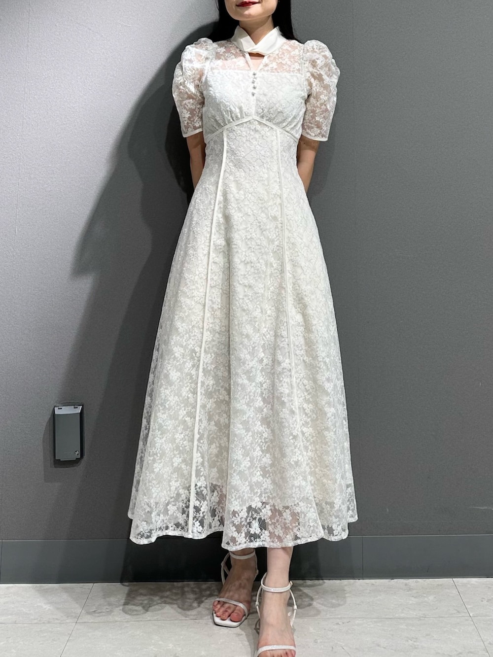 ホワイト系のドレス、ホワイト系のサンダルを着用したレディースの夏コーディネートの3枚目の写真