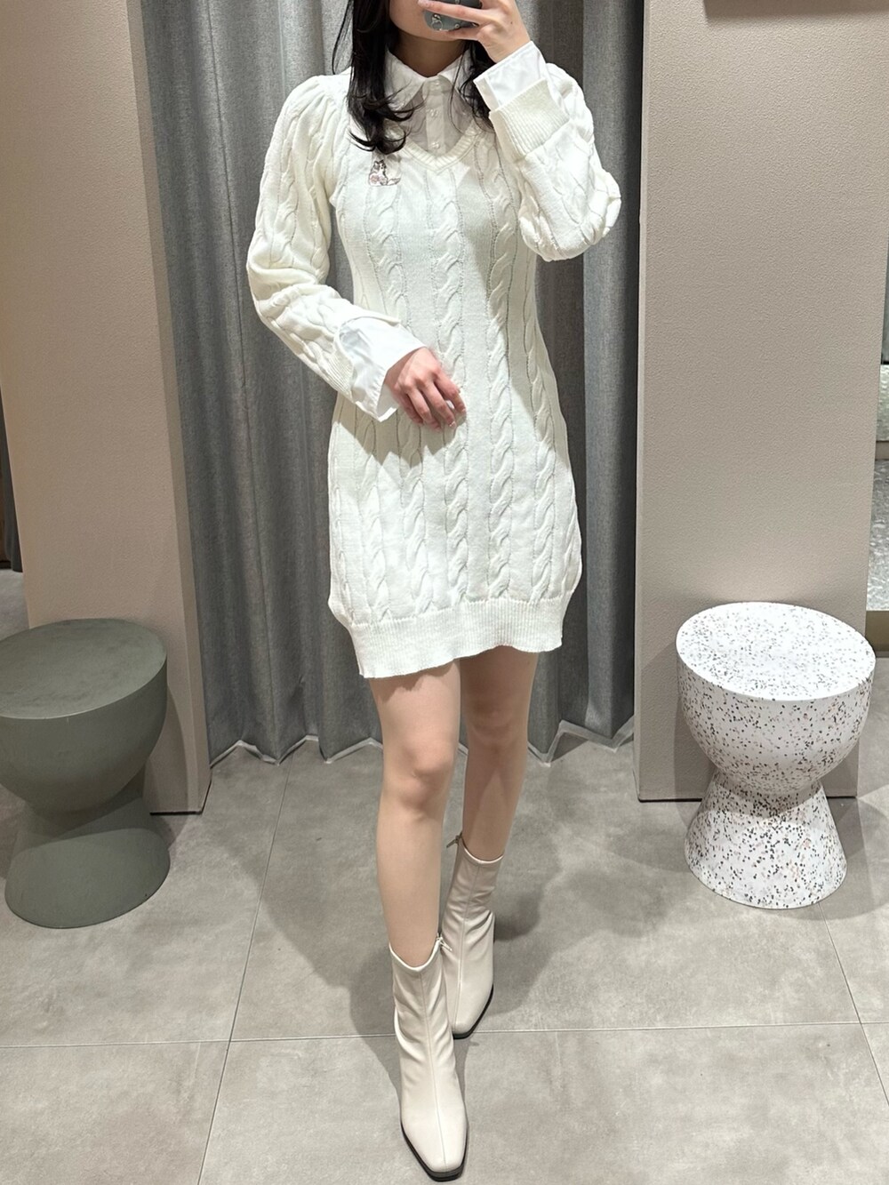 ホワイト系のワンピース、ベージュ系のブーツを着用したレディースの冬コーディネートの2枚目の写真
