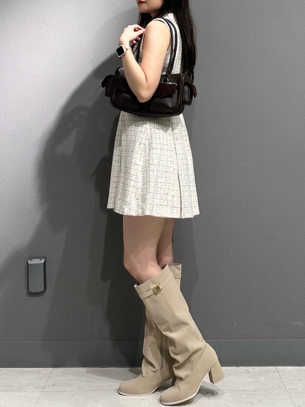 ホワイト系のワンピース、ブラウン系のボストンバッグ、ホワイト系のブーツを着用したレディースの夏コーディネートの4枚目の写真