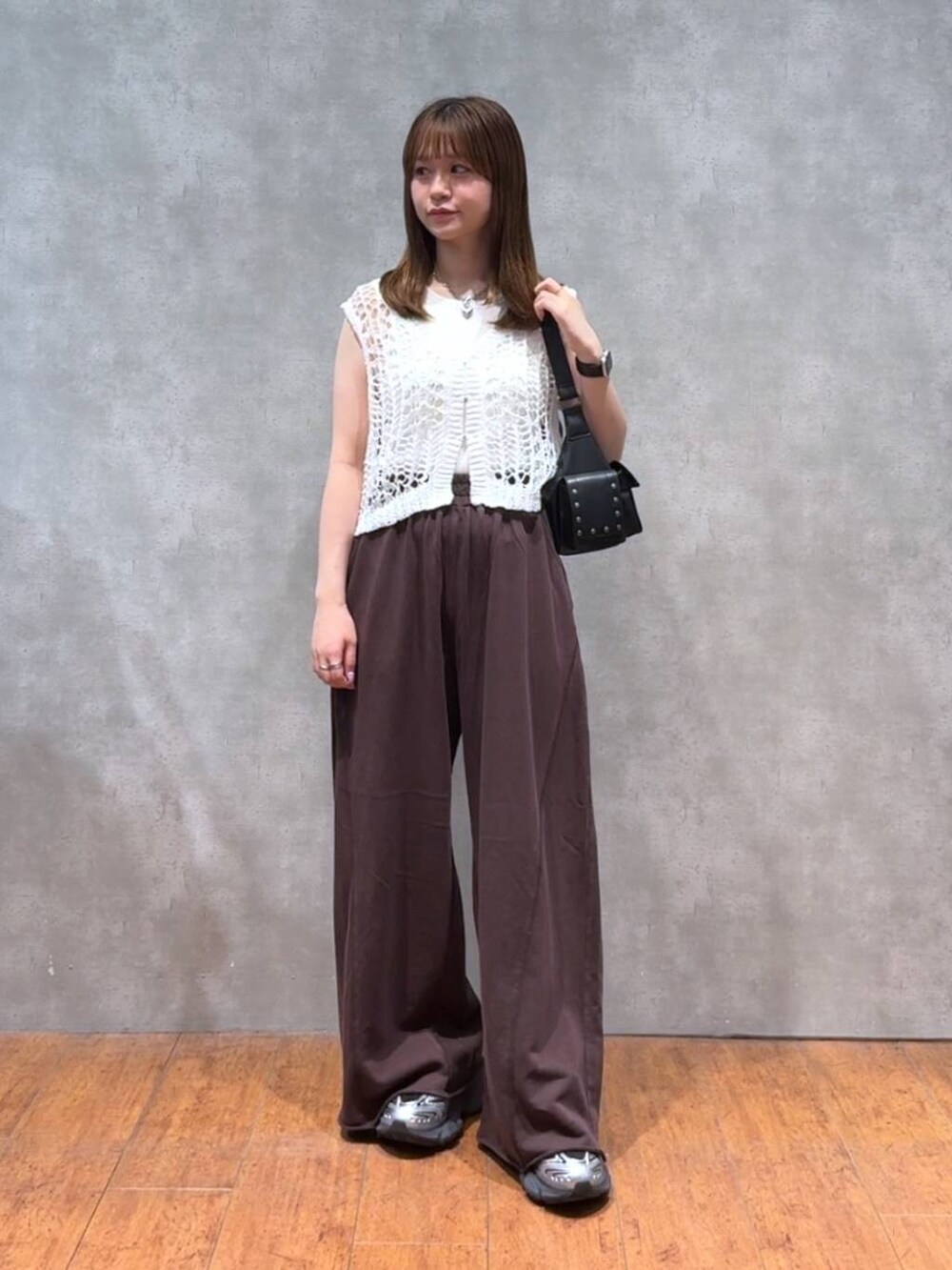ブラック系のショルダーバッグ、ブラウン系のスウェットパンツ、ホワイト系のTシャツ/カットソーを着用したレディースの夏コーディネートの4枚目の写真