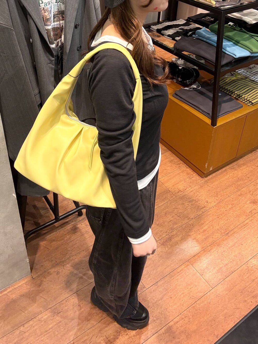 ブラック系のスニーカー、ブラック系のデニムパンツ、イエロー系のトートバッグを着用したレディースの春コーディネートの2枚目の写真