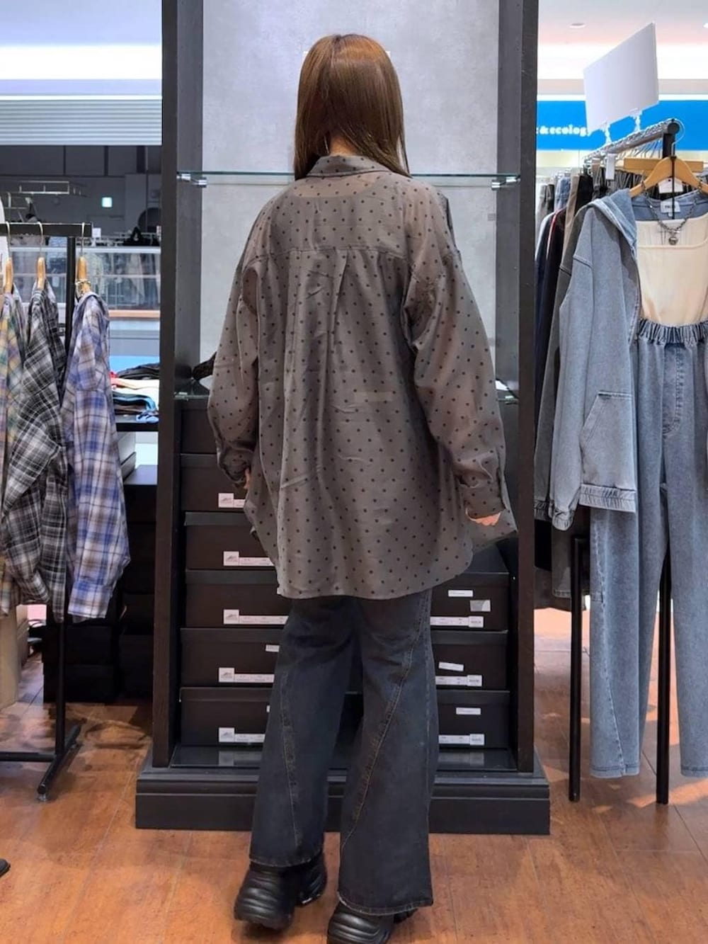 ブラック系のスニーカー、ブルー系のデニムパンツ、ブラック系のタンクトップを着用したレディースの春コーディネートの3枚目の写真