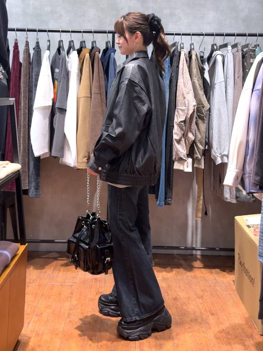 ブラック系のスニーカー、ブルー系のデニムパンツ、ブラック系のブルゾンを着用したレディースの秋コーディネートの2枚目の写真