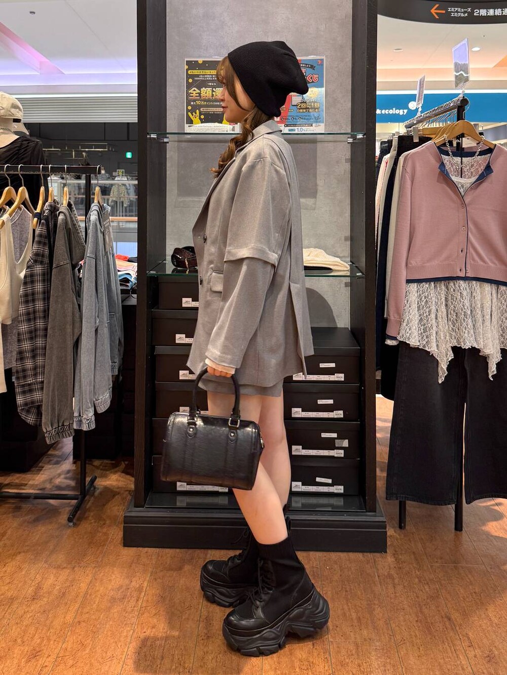 ブラック系のブーツ、ホワイト系のTシャツ/カットソー、ブラック系のボストンバッグを着用したレディースの春コーディネートの2枚目の写真