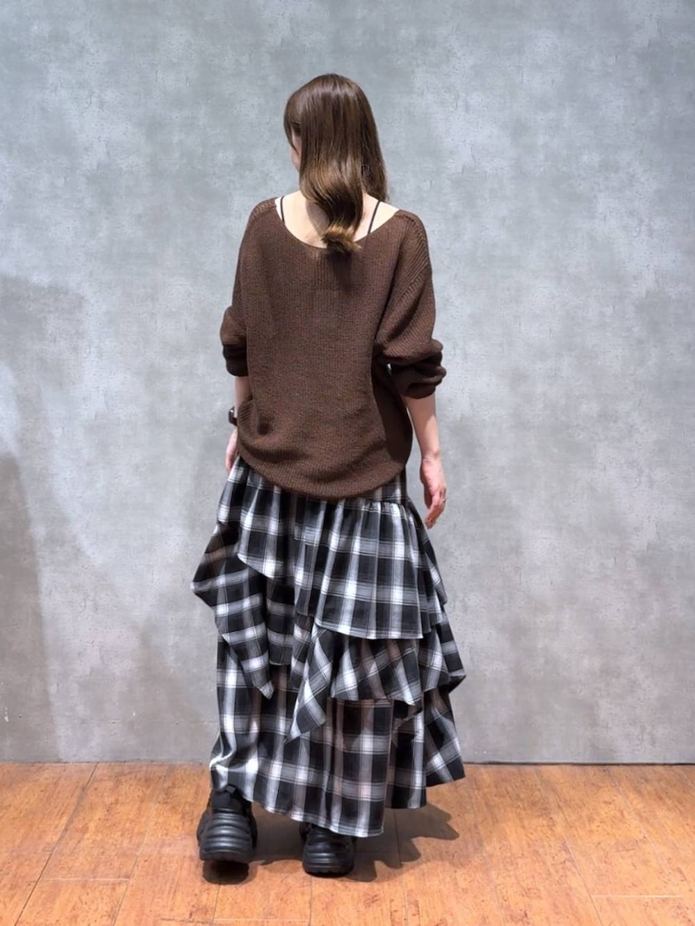 ブラック系のスニーカー、ブラウン系のニット/セーター、ホワイト系のスカートを着用したレディースの秋コーディネートの4枚目の写真