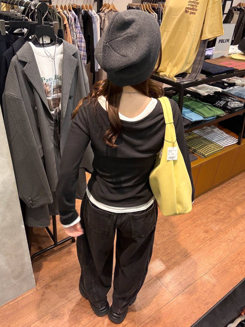 ブラック系のスニーカー、ブラック系のデニムパンツ、イエロー系のトートバッグを着用したレディースの春コーディネートの3枚目の写真