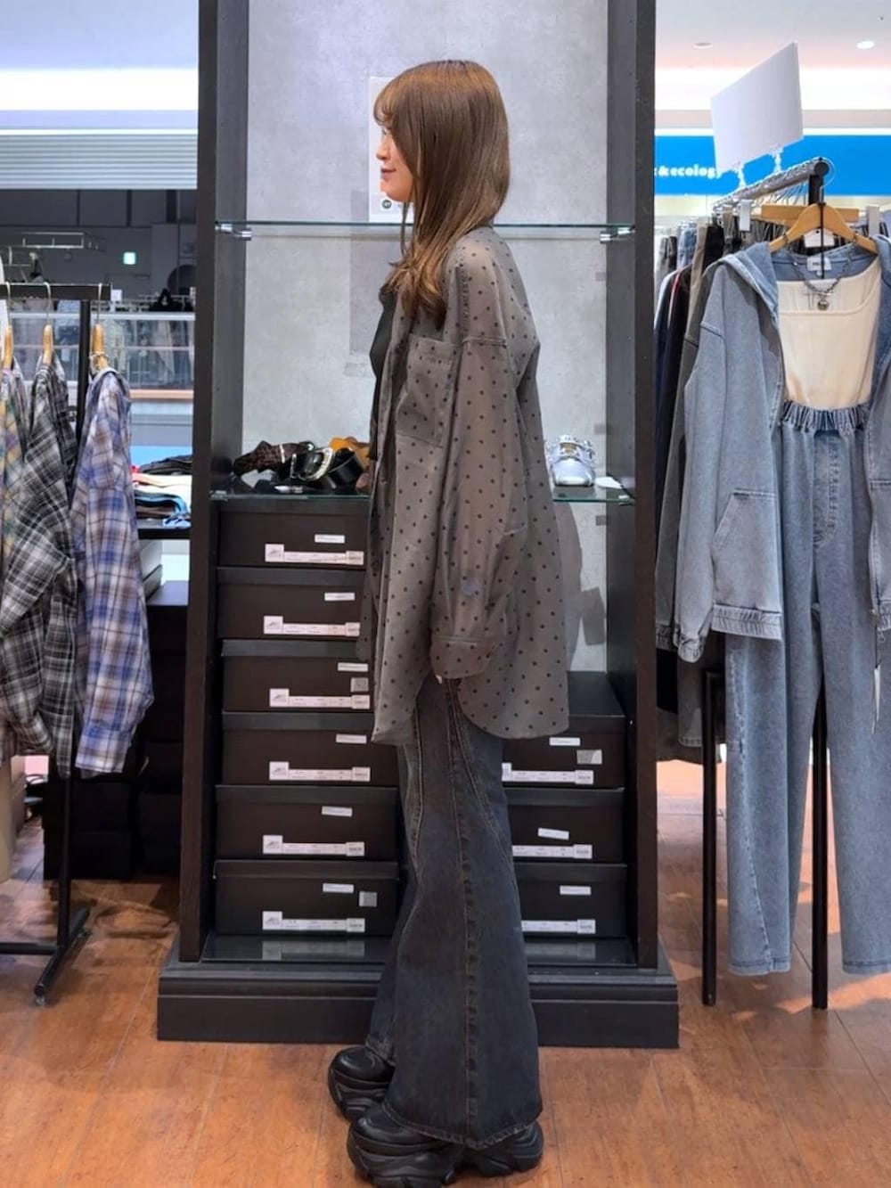 ブラック系のスニーカー、ブルー系のデニムパンツ、ブラック系のタンクトップを着用したレディースの春コーディネートの2枚目の写真