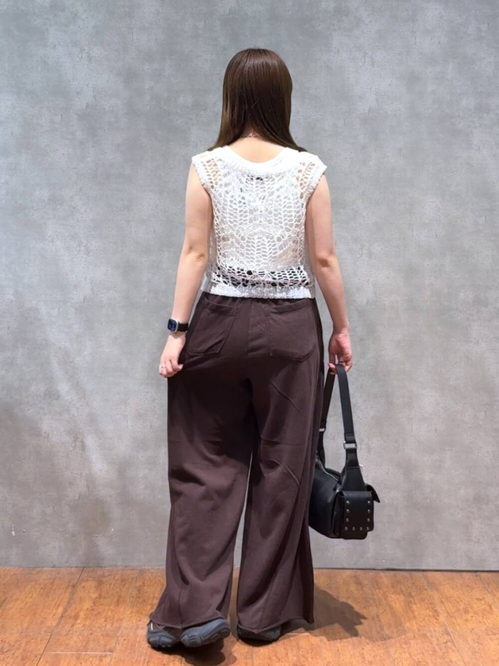 ブラック系のショルダーバッグ、ブラウン系のスウェットパンツ、ホワイト系のTシャツ/カットソーを着用したレディースの夏コーディネートの3枚目の写真