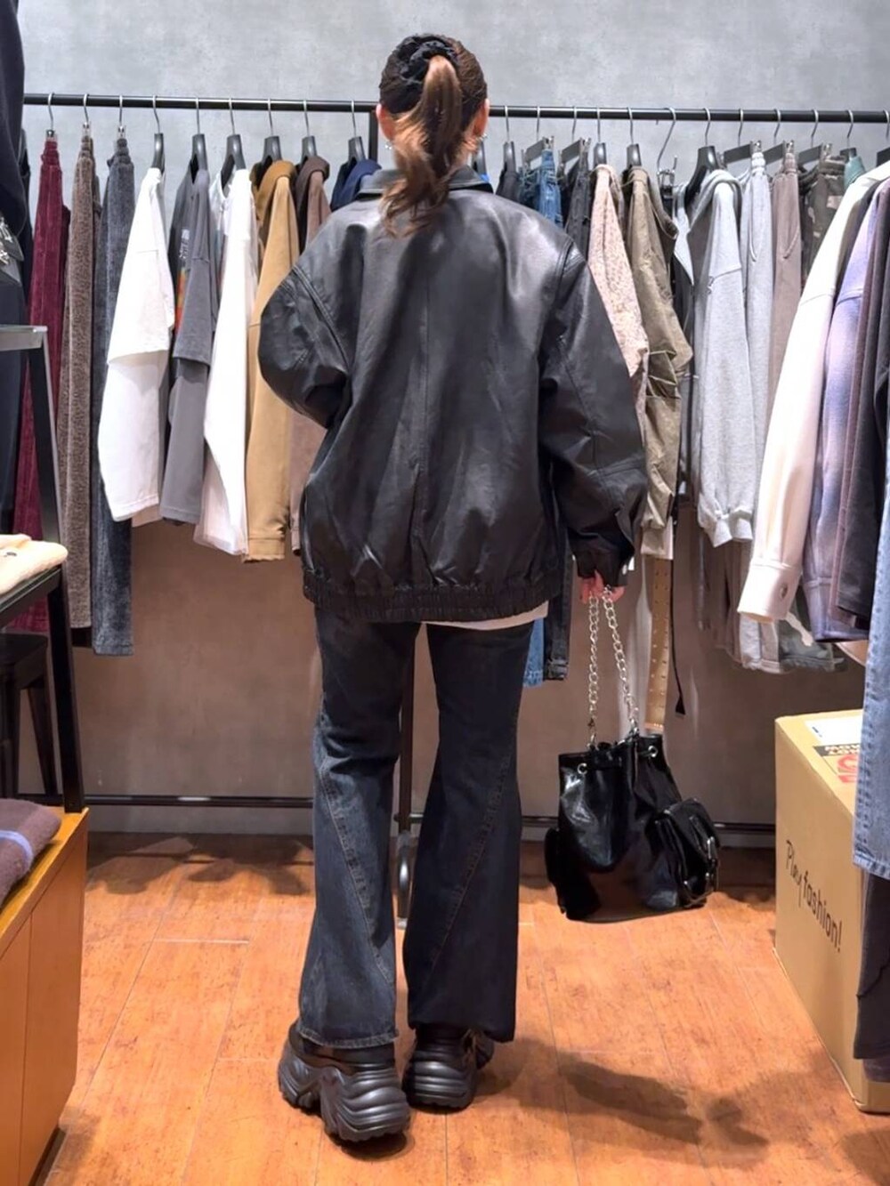 ブラック系のスニーカー、ブルー系のデニムパンツ、ブラック系のブルゾンを着用したレディースの秋コーディネートの3枚目の写真