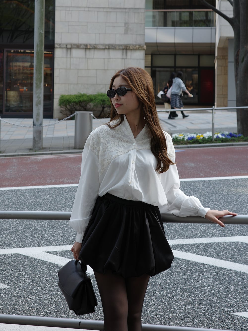 ホワイト系のシャツ/ブラウス、ブラック系のスカート、ブラック系のハンドバッグを着用したレディースの春コーディネートの2枚目の写真