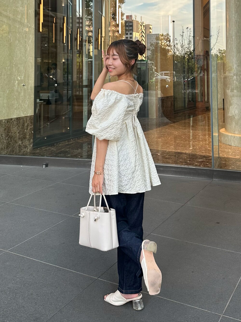 ホワイト系のシャツ/ブラウス、ホワイト系のバッグ、ホワイト系のサンダルを着用したレディースの夏コーディネートの2枚目の写真