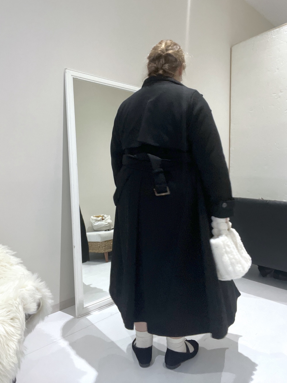 ブラック系のチェスターコート、ブラウン系のニット/セーター、グレー系のワンピースを着用したレディースの冬コーディネートの5枚目の写真