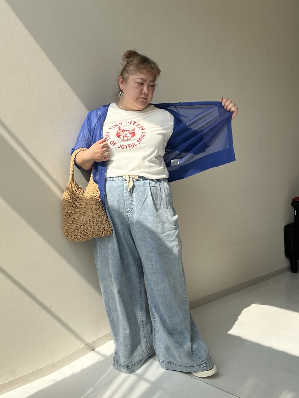 ホワイト系のチュニック、ブルー系のパンツ、ブルー系のカーディガン/ボレロを着用したレディースの夏コーディネートの3枚目の写真