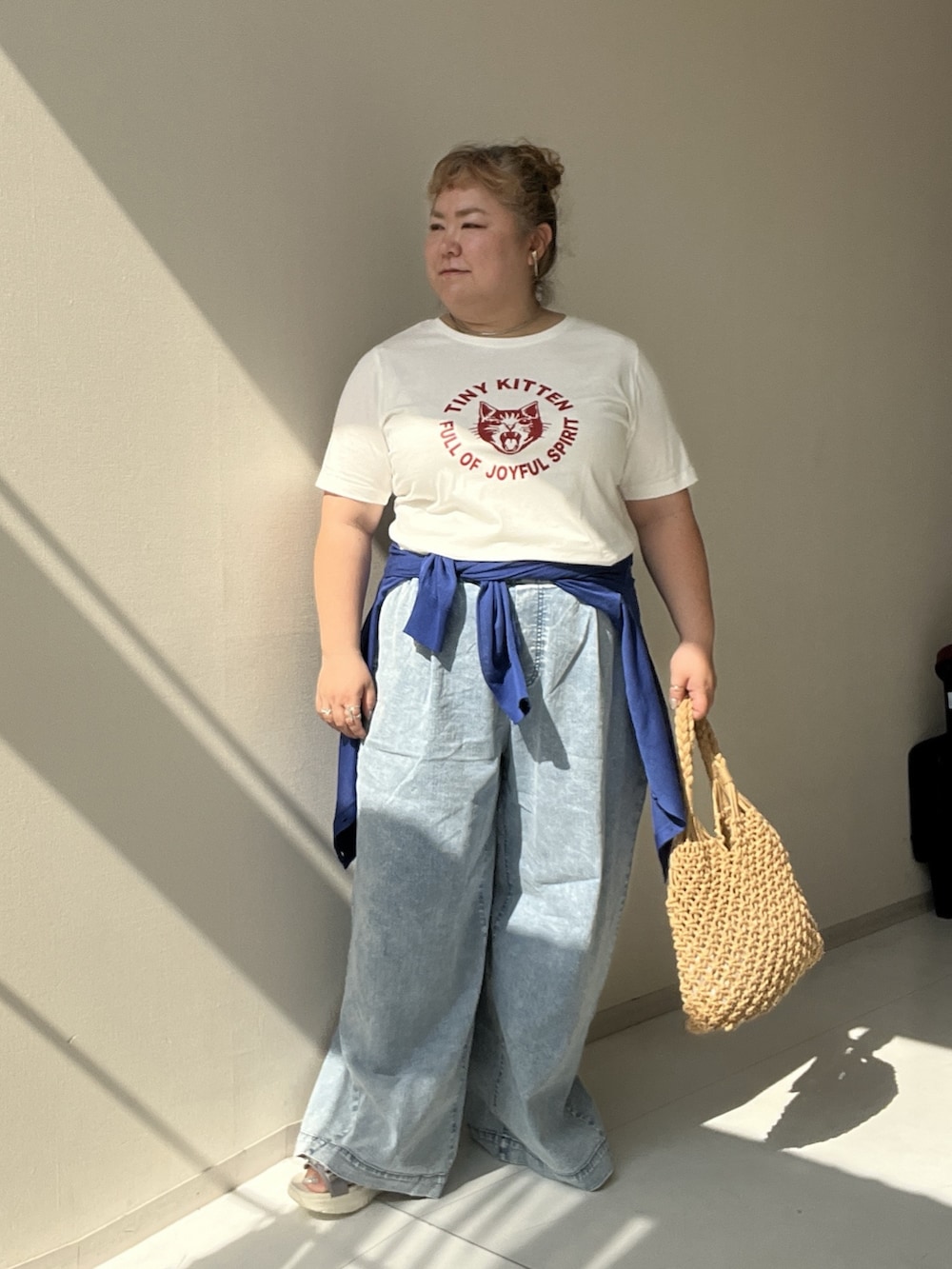 ホワイト系のチュニック、ブルー系のパンツ、ブルー系のカーディガン/ボレロを着用したレディースの夏コーディネートの6枚目の写真