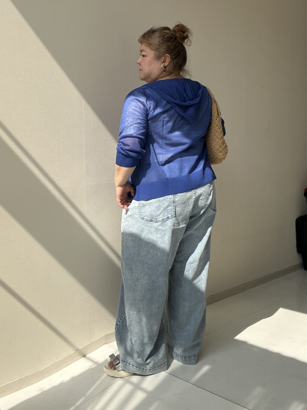 ホワイト系のチュニック、ブルー系のパンツ、ブルー系のカーディガン/ボレロを着用したレディースの夏コーディネートの4枚目の写真