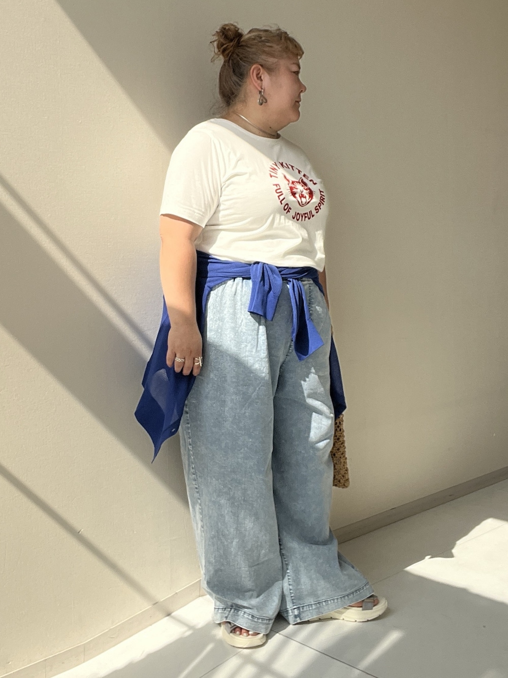 ホワイト系のチュニック、ブルー系のパンツ、ブルー系のカーディガン/ボレロを着用したレディースの夏コーディネートの7枚目の写真