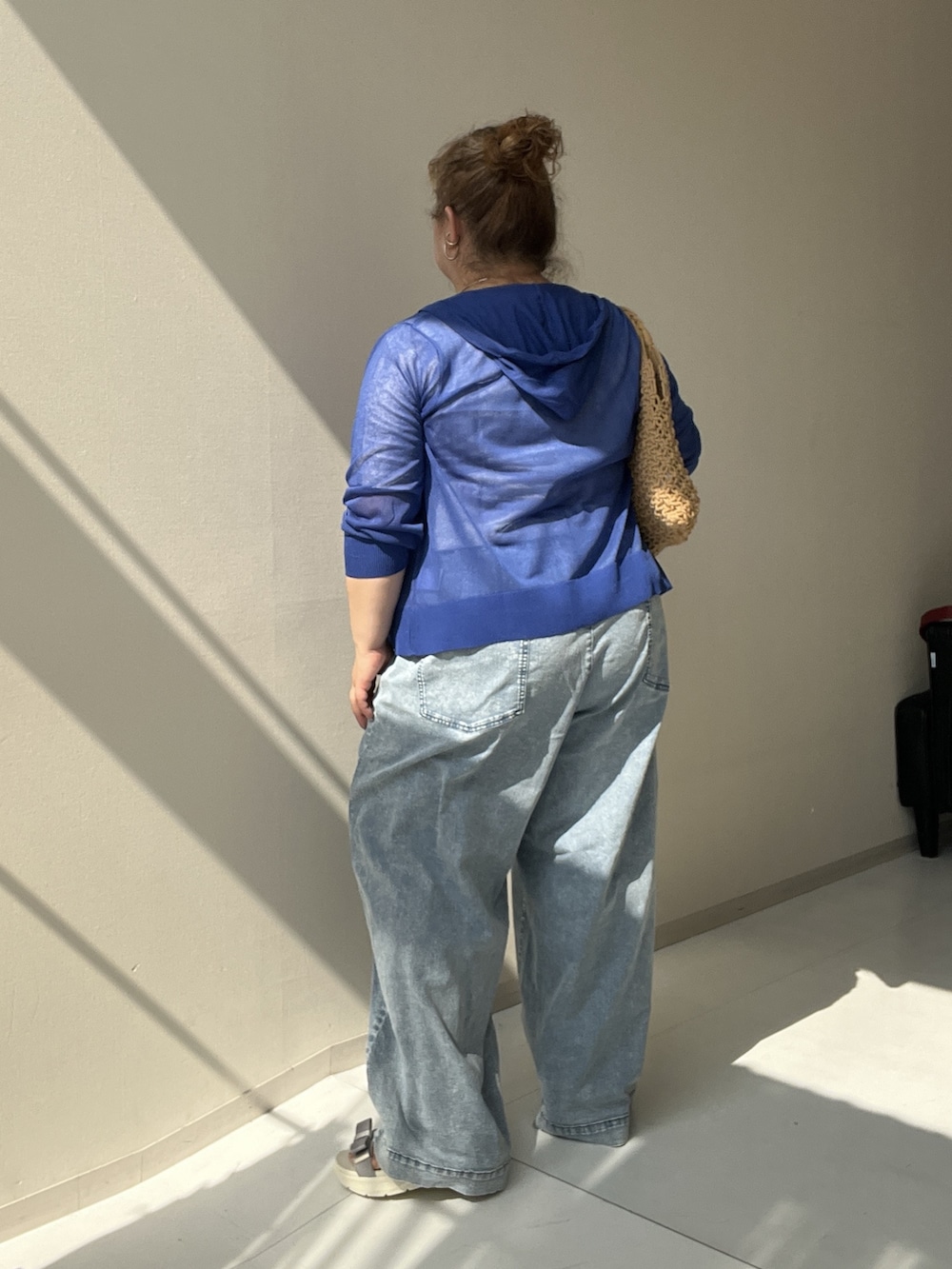 ホワイト系のチュニック、ブルー系のパンツ、ブルー系のカーディガン/ボレロを着用したレディースの夏コーディネートの5枚目の写真