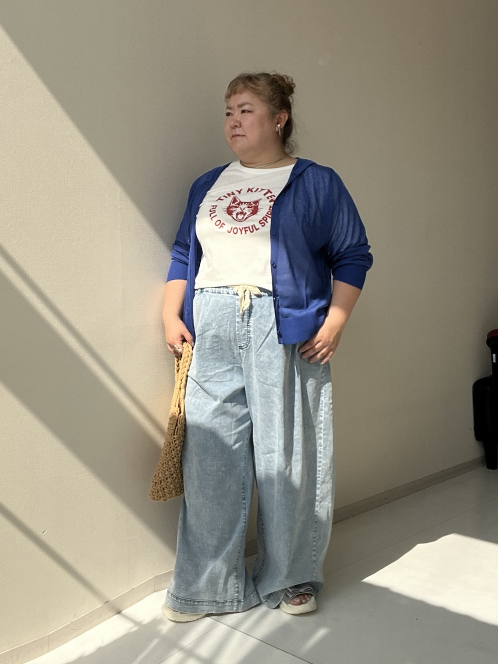 ホワイト系のチュニック、ブルー系のパンツ、ブルー系のカーディガン/ボレロを着用したレディースの夏コーディネートの2枚目の写真