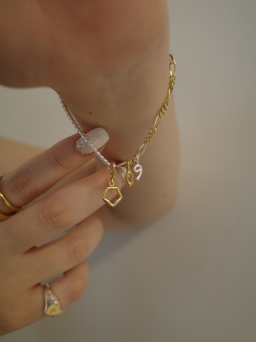 シルバー系のリング、ゴールド系のリング、シルバー系のブレスレットを着用したレディースの夏コーディネートの2枚目の写真