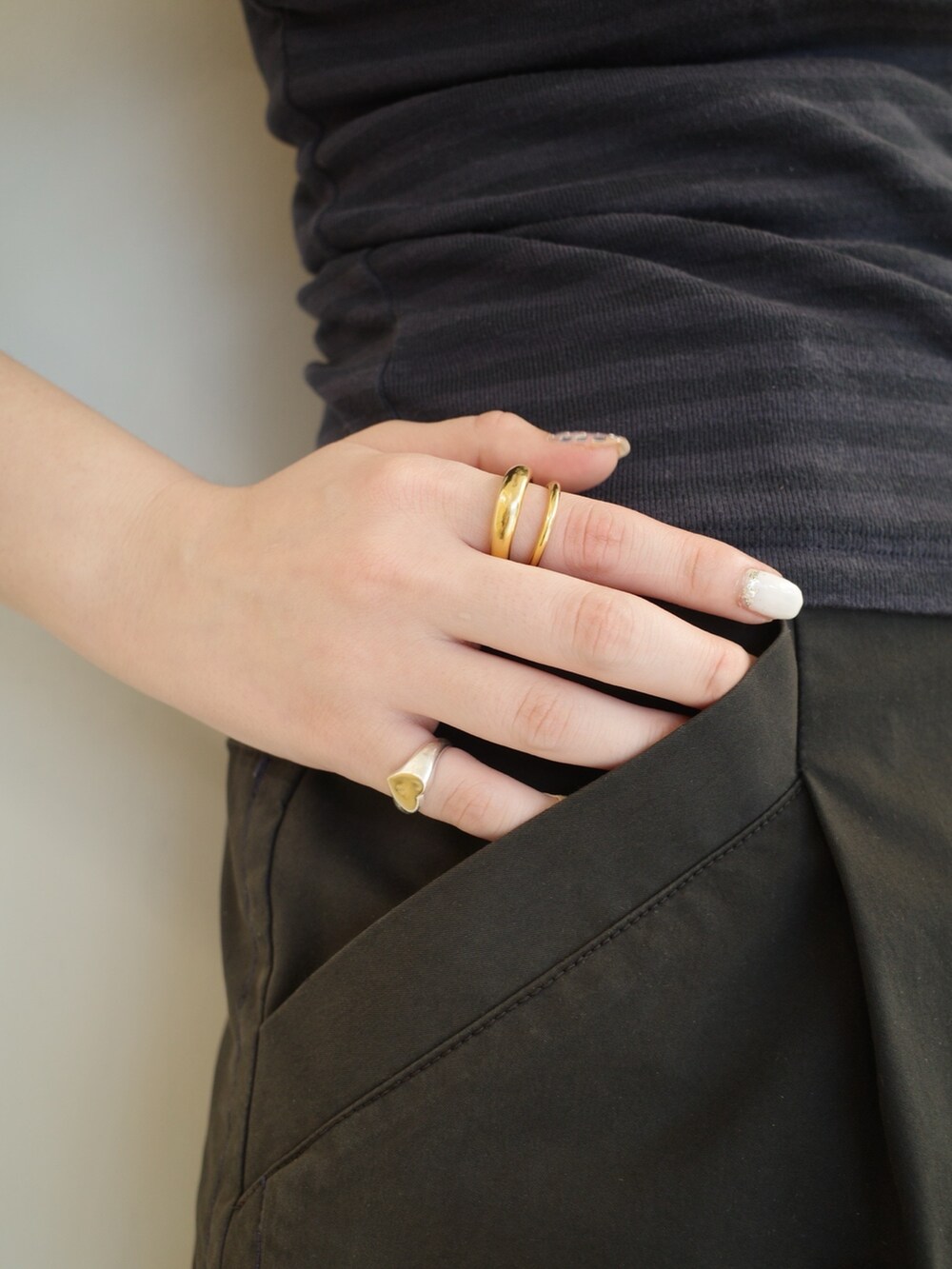 シルバー系のリング、ゴールド系のリング、シルバー系のブレスレットを着用したレディースの夏コーディネートの4枚目の写真