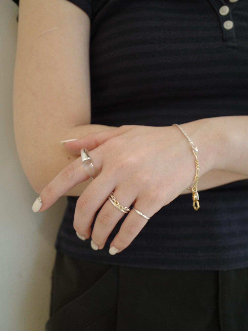 シルバー系のリング、ゴールド系のリング、シルバー系のブレスレットを着用したレディースの夏コーディネートの3枚目の写真