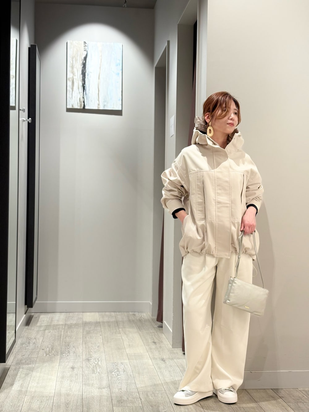 ブルー系のニット/セーター、ホワイト系のスラックス、ベージュ系のブルゾンを着用したレディースの冬コーディネートの2枚目の写真