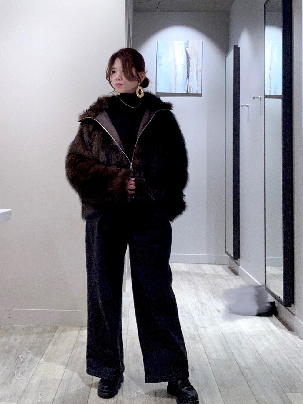 ブラック系のデニムパンツ、ブラック系のニット/セーター、ブラウン系のブルゾンを着用したレディースの秋コーディネートの2枚目の写真
