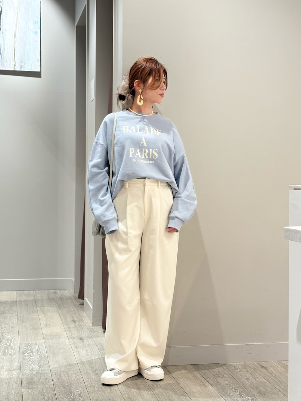 ブルー系のデニムジャケット、ホワイト系のスラックスを着用したレディースの春コーディネートの2枚目の写真