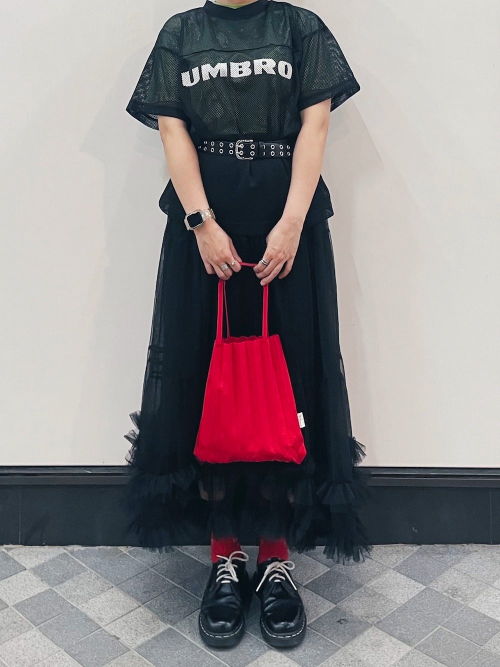 ブラック系のTシャツ/カットソー、レッド系のバッグ、ブラック系のブーツを着用したレディースの春コーディネートの2枚目の写真