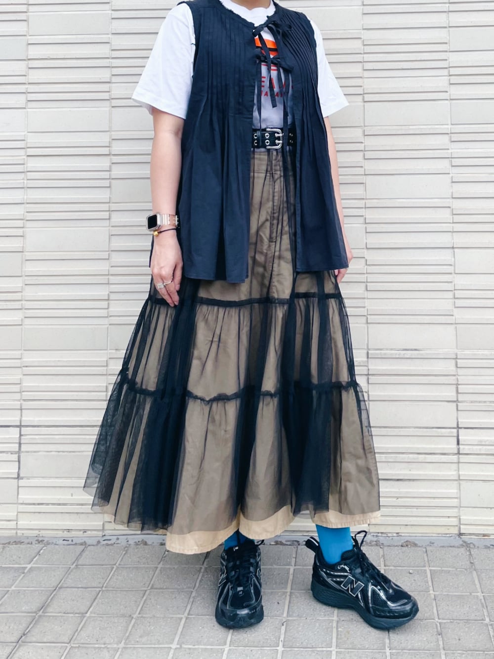 ブルー系のベスト、ホワイト系のTシャツ/カットソー、ブラック系のワンピースを着用したレディースの春コーディネートの2枚目の写真
