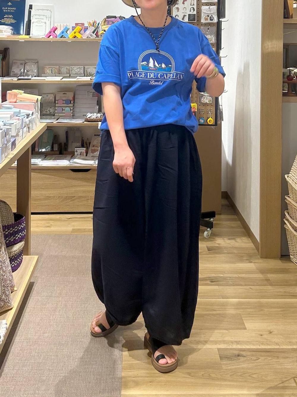 ブラック系のサンダル、ブルー系のその他パンツ、ベージュ系のハットを着用したレディースの夏コーディネートの2枚目の写真