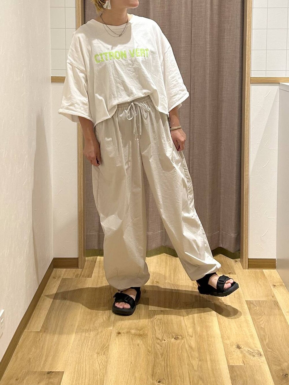 ブラック系のサンダル、グリーン系のTシャツ/カットソー、グレー系のその他パンツを着用したレディースの夏コーディネートの2枚目の写真