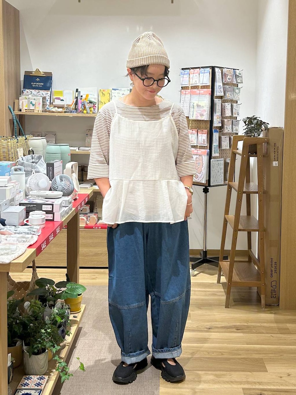 ブルー系のデニムパンツ、ブラック系のサンダル、その他のTシャツ/カットソーを着用したレディースの秋コーディネートの2枚目の写真