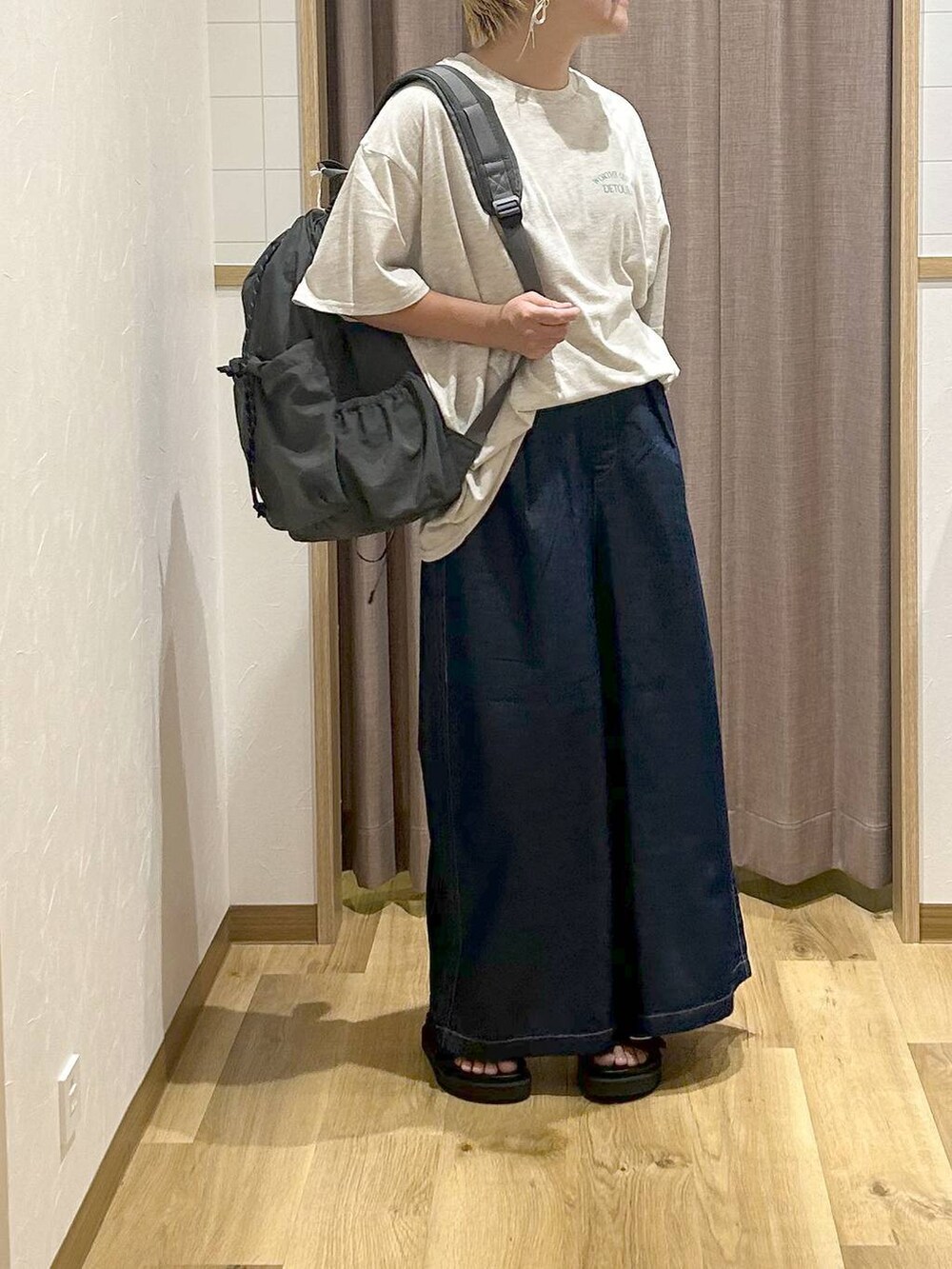 グレー系のバックパック/リュック、ブルー系のデニムパンツ、ブラック系のサンダルを着用したレディースの夏コーディネートの3枚目の写真