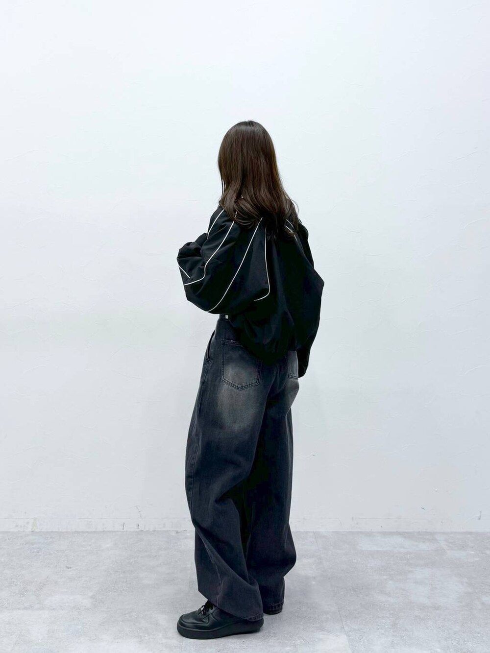 ブラック系のブルゾン、ブラック系のデニムパンツ、グレー系のTシャツ/カットソーを着用したレディースの春コーディネートの2枚目の写真