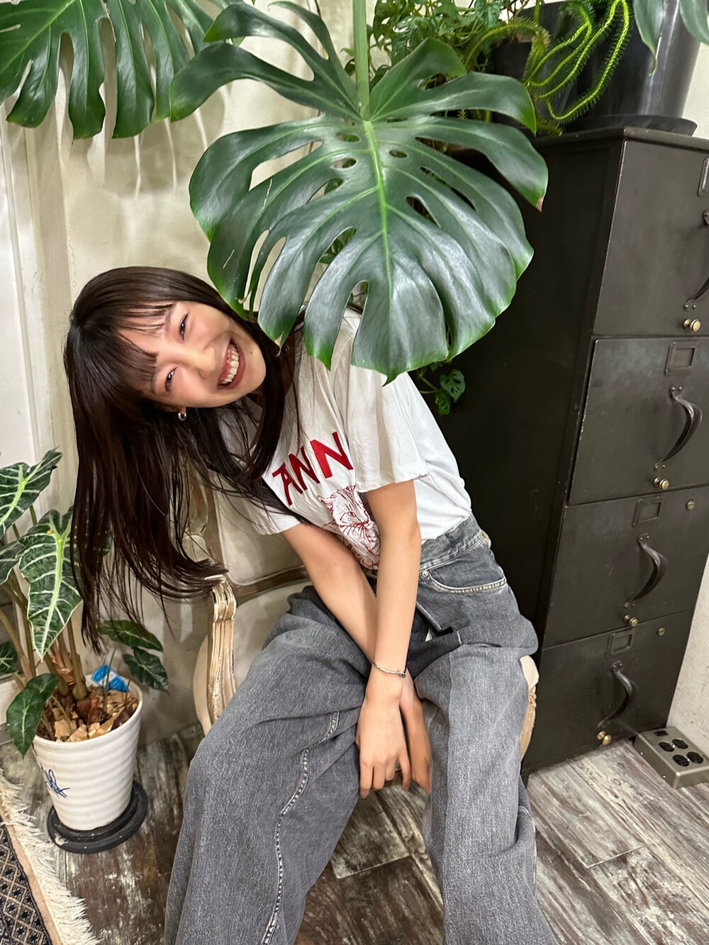 ホワイト系のTシャツ/カットソー、ブラック系のデニムパンツ、ブラック系のブーツを着用したレディースの夏コーディネートの2枚目の写真