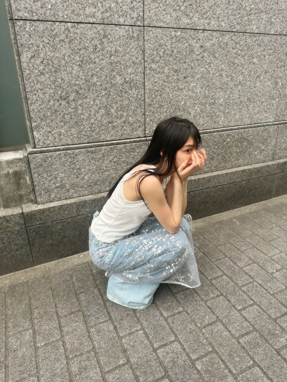 ホワイト系のタンクトップ、シルバー系のスカート、ブルー系のデニムパンツを着用したレディースの夏コーディネートの2枚目の写真