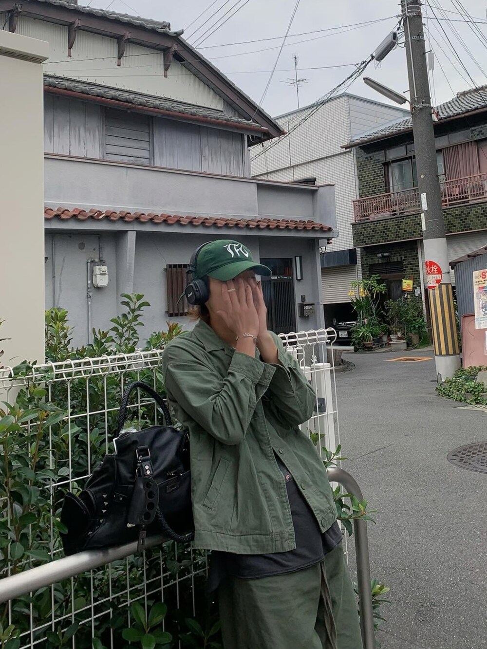 ブラック系のショルダーバッグ、イエロー系のネックレスを着用したメンズの冬コーディネートの3枚目の写真