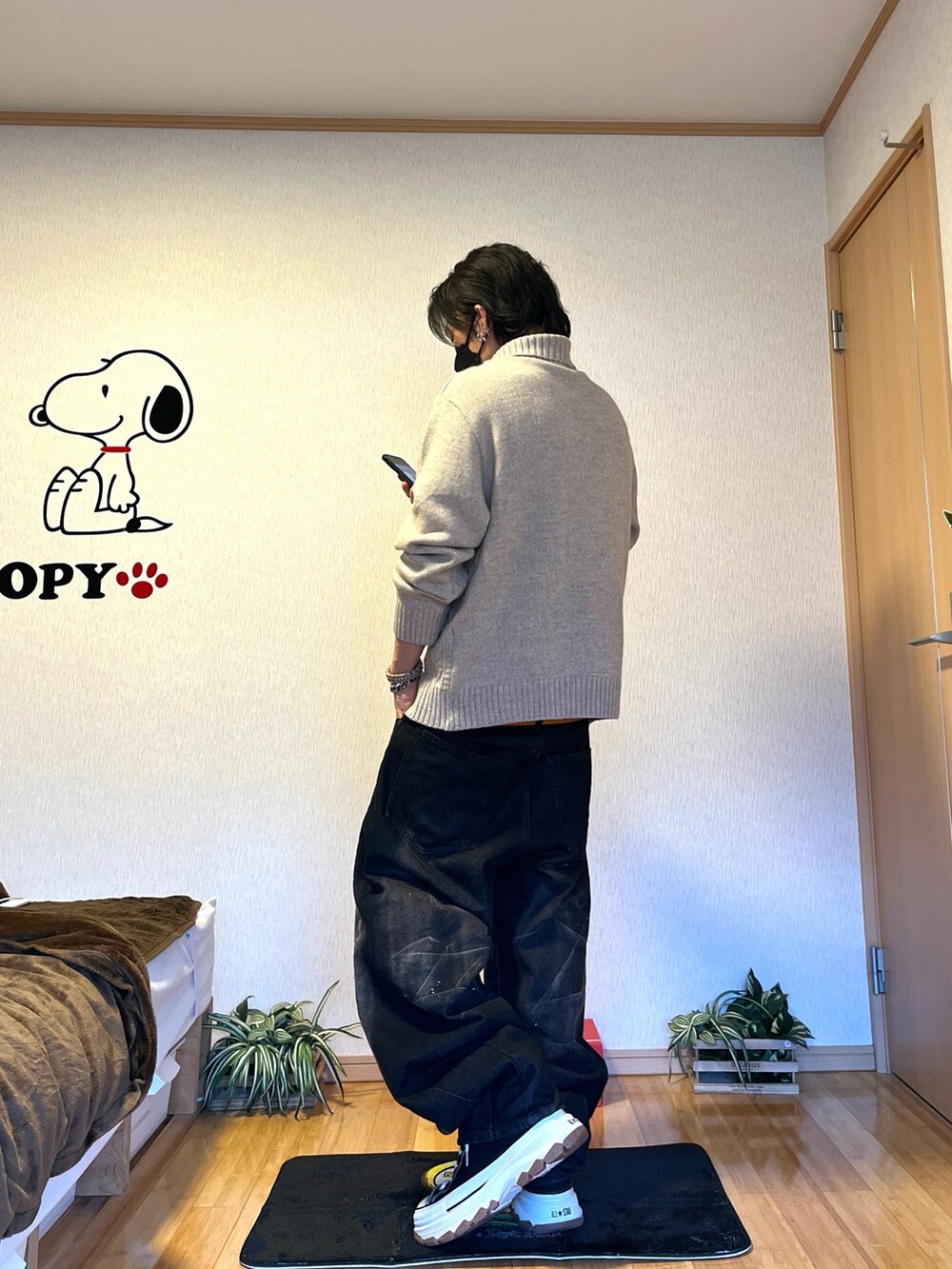 ブラウン系のブルゾン、ベージュ系のニット/セーター、ブラック系のスニーカーを着用したメンズの冬コーディネートの4枚目の写真