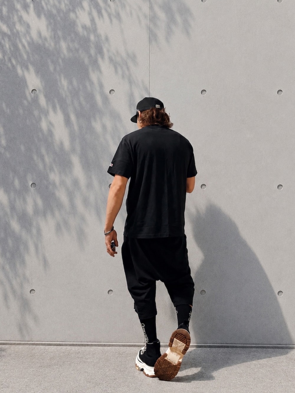 ブラック系のTシャツ/カットソー、ブラック系のその他パンツ、ブラック系のスニーカーを着用したメンズの夏コーディネートの2枚目の写真