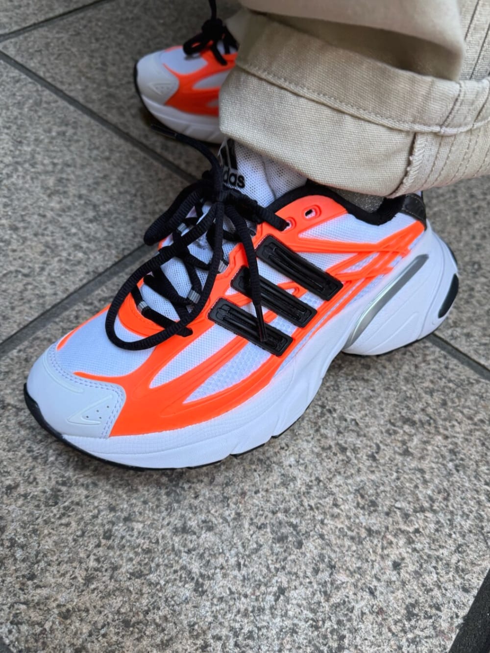 ホワイト系のスニーカー、ブラック系のブルゾン、ベージュ系のその他パンツを着用したレディースの春コーディネートの2枚目の写真