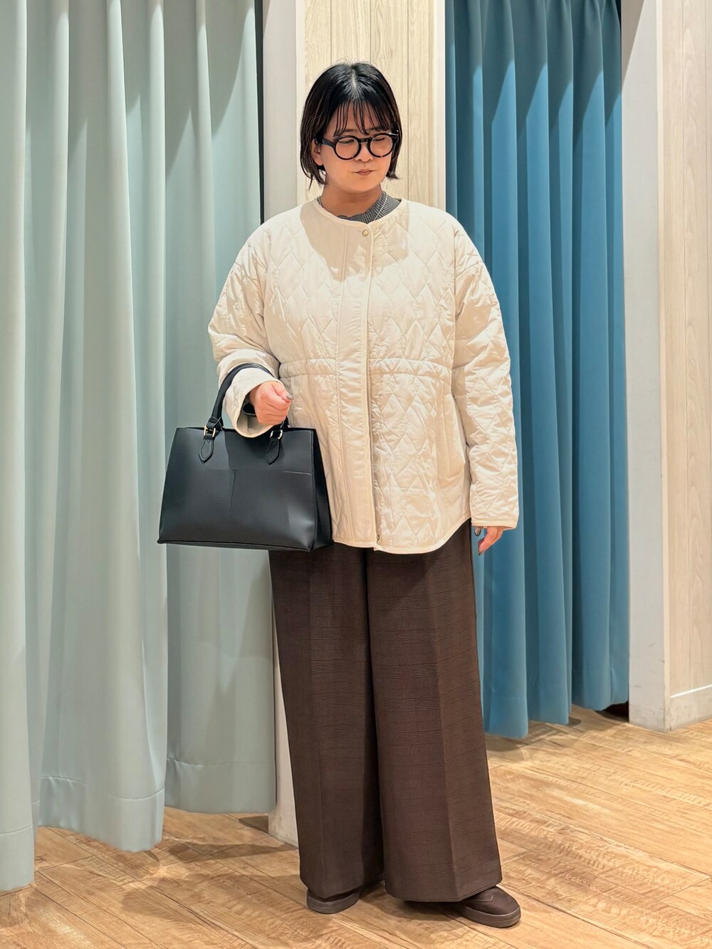 ホワイト系のノーカラージャケット、グレー系のニット/セーター、ブラウン系のその他パンツを着用したレディースの秋コーディネートの4枚目の写真
