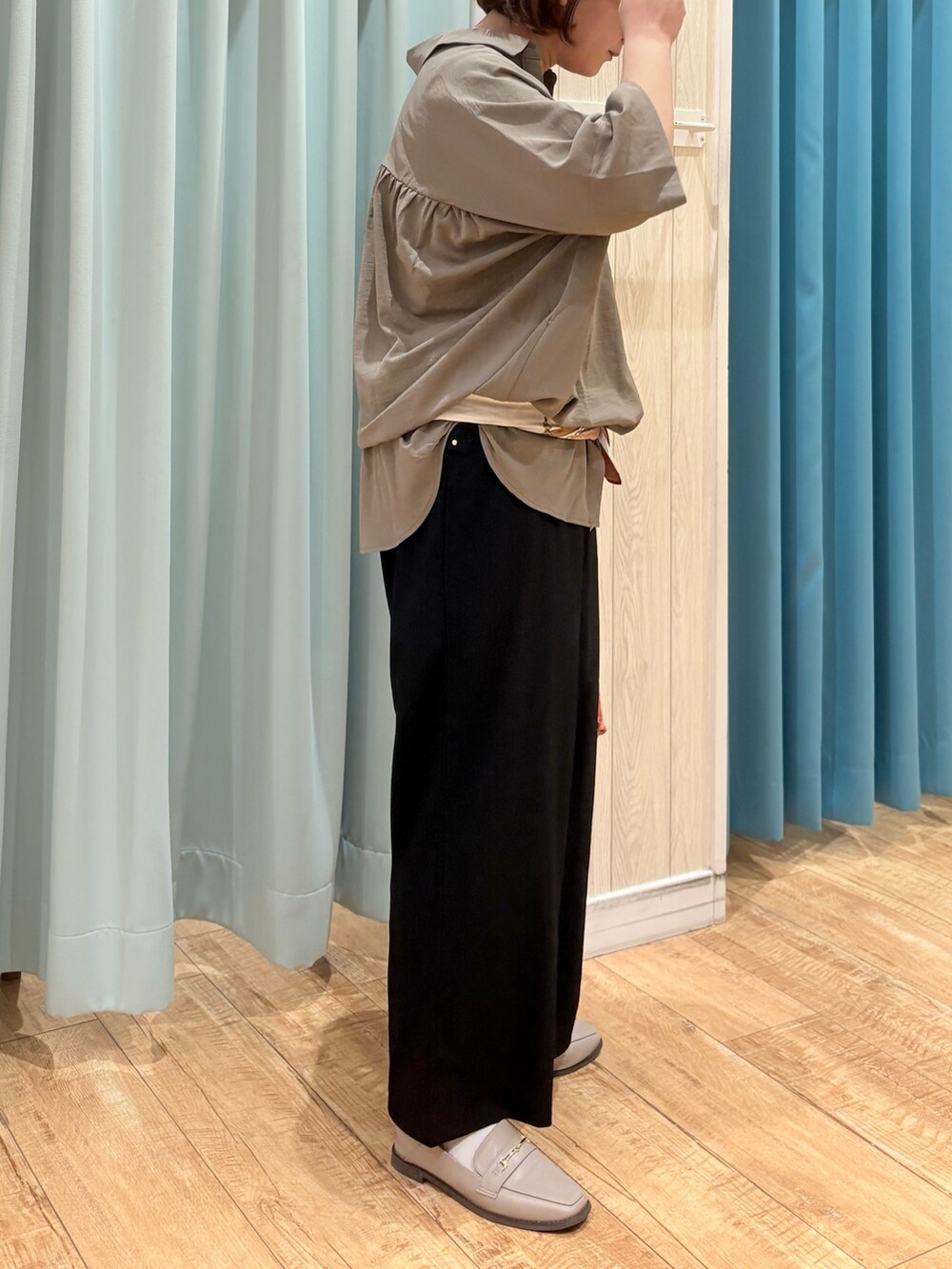 ブラウン系のチュニック、ブラック系のその他パンツ、オレンジ系のショルダーバッグを着用したレディースの秋コーディネートの4枚目の写真