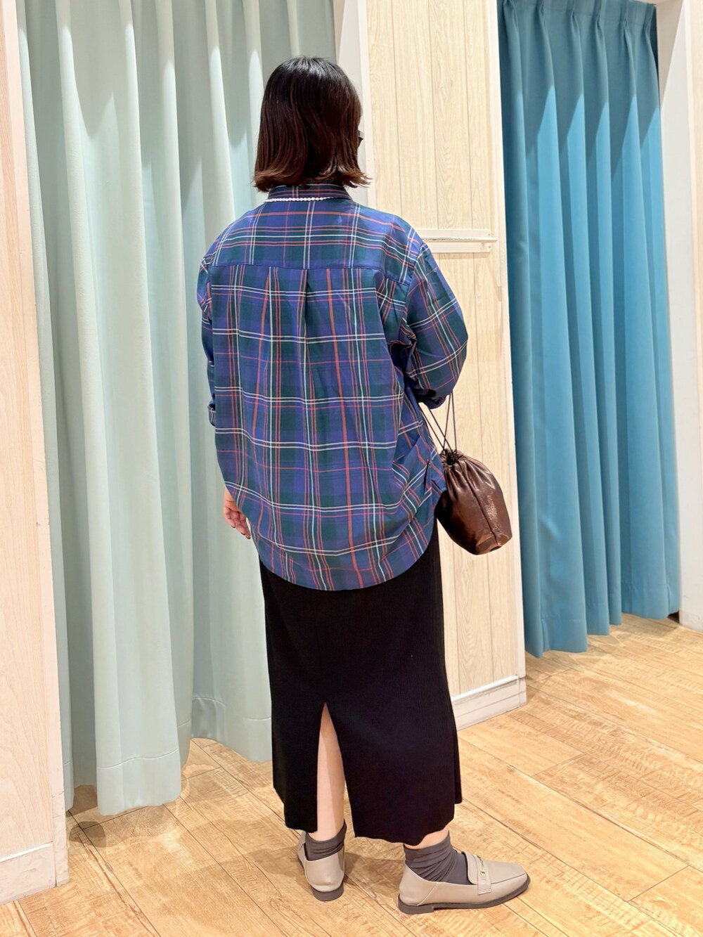 グリーン系のシャツ/ブラウス、ブラック系のスカート、その他のショルダーバッグを着用したレディースの秋コーディネートの4枚目の写真