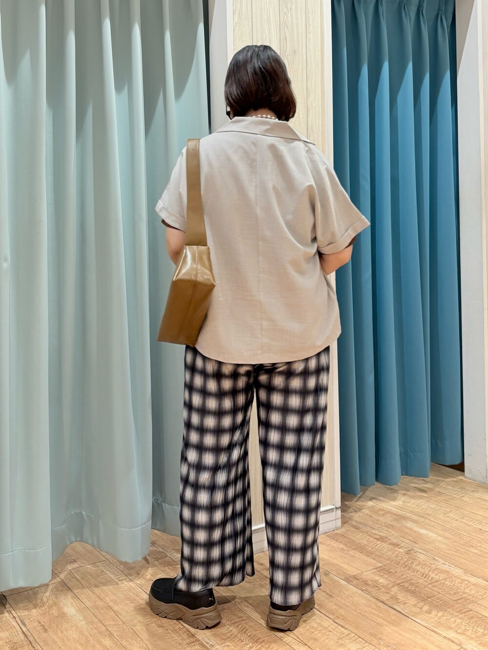 ベージュ系のテーラードジャケット、ブラウン系のTシャツ/カットソー、シルバー系のネックレスを着用したレディースの夏コーディネートの4枚目の写真