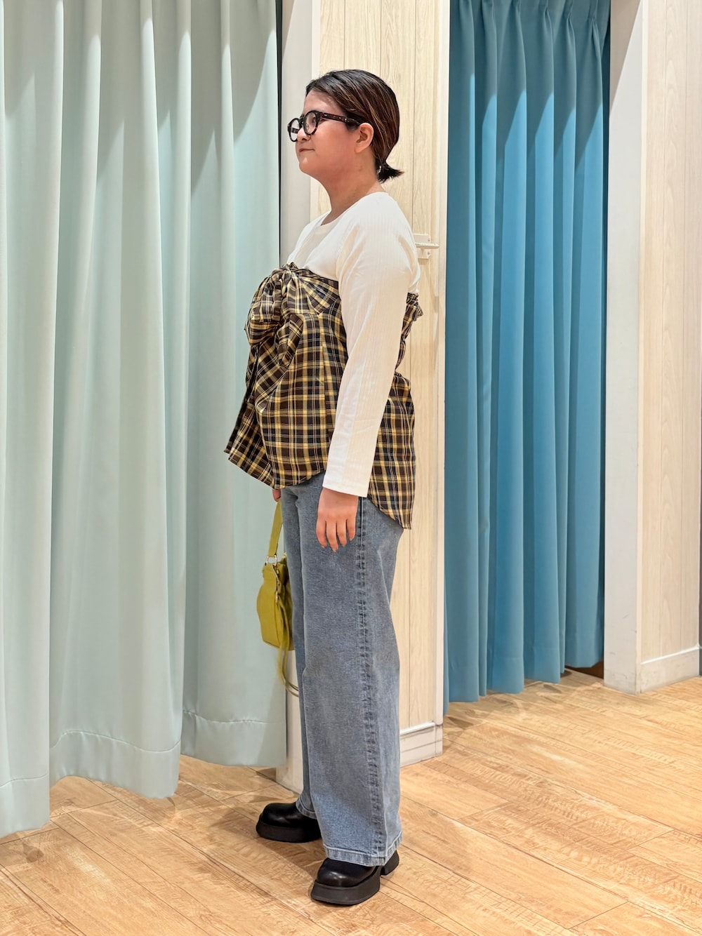 イエロー系のシャツ/ブラウス、ホワイト系のTシャツ/カットソー、ブルー系のデニムパンツを着用したレディースの秋コーディネートの2枚目の写真