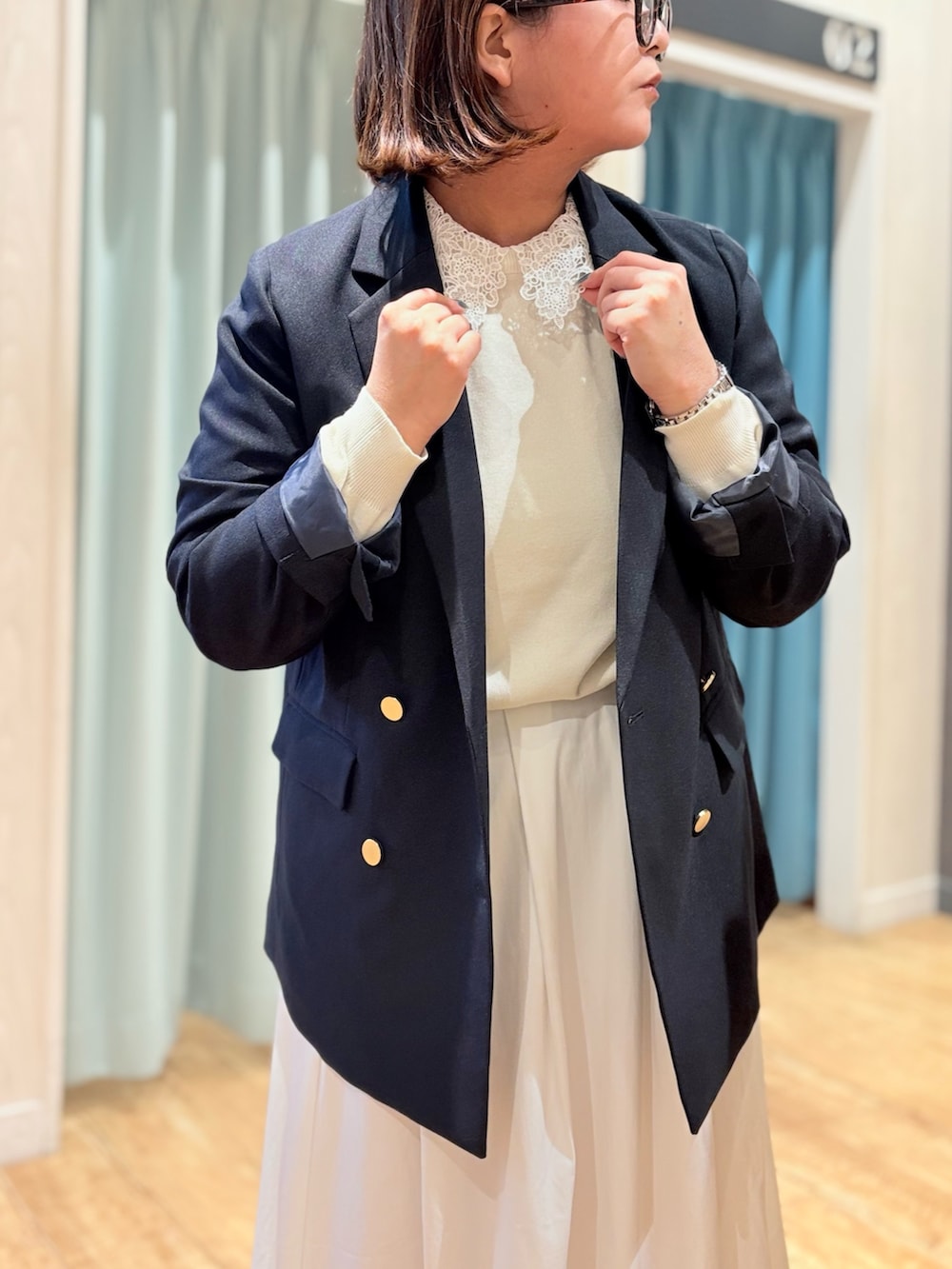 ブルー系のテーラードジャケット、ホワイト系のニット/セーターを着用したレディースの秋コーディネートの6枚目の写真